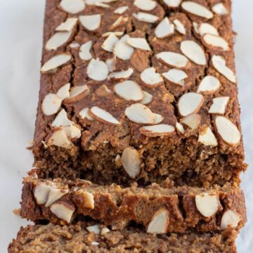 a loaf of flourless banana bread using rolled oats with almond slices toppings