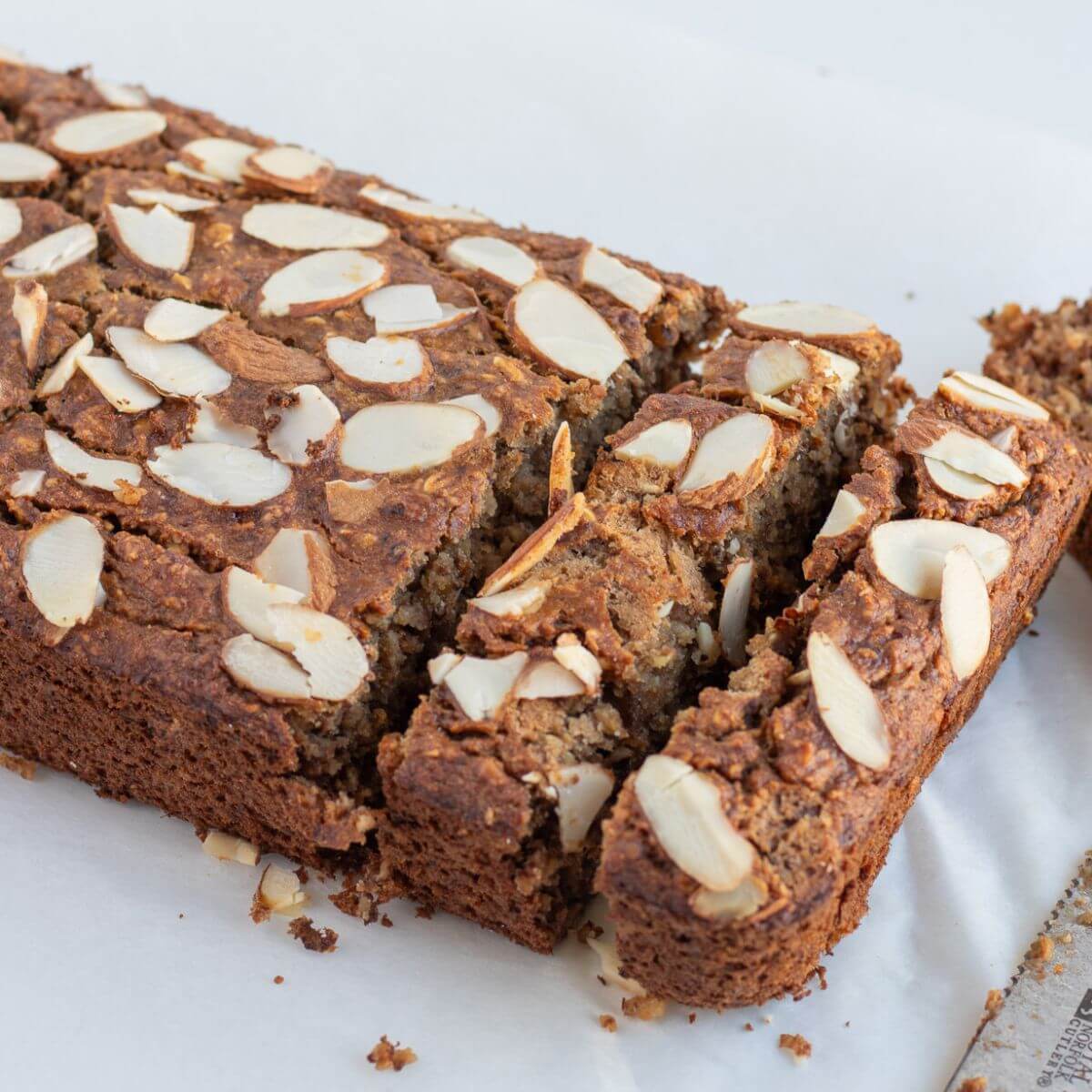 a loaf of flourless banana bread using rolled oats with almond slices toppings