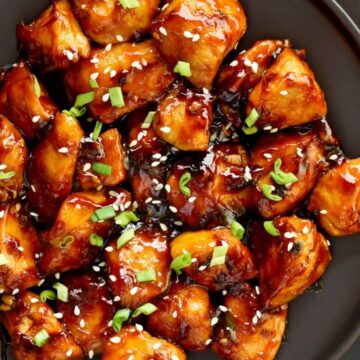 teriyaki chicken on a black plate