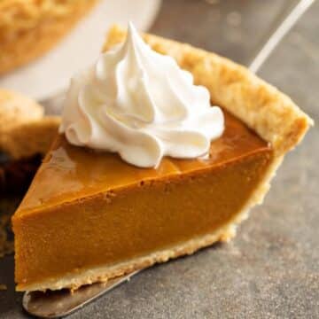 sliced pumpkin pie with whipped cream on top