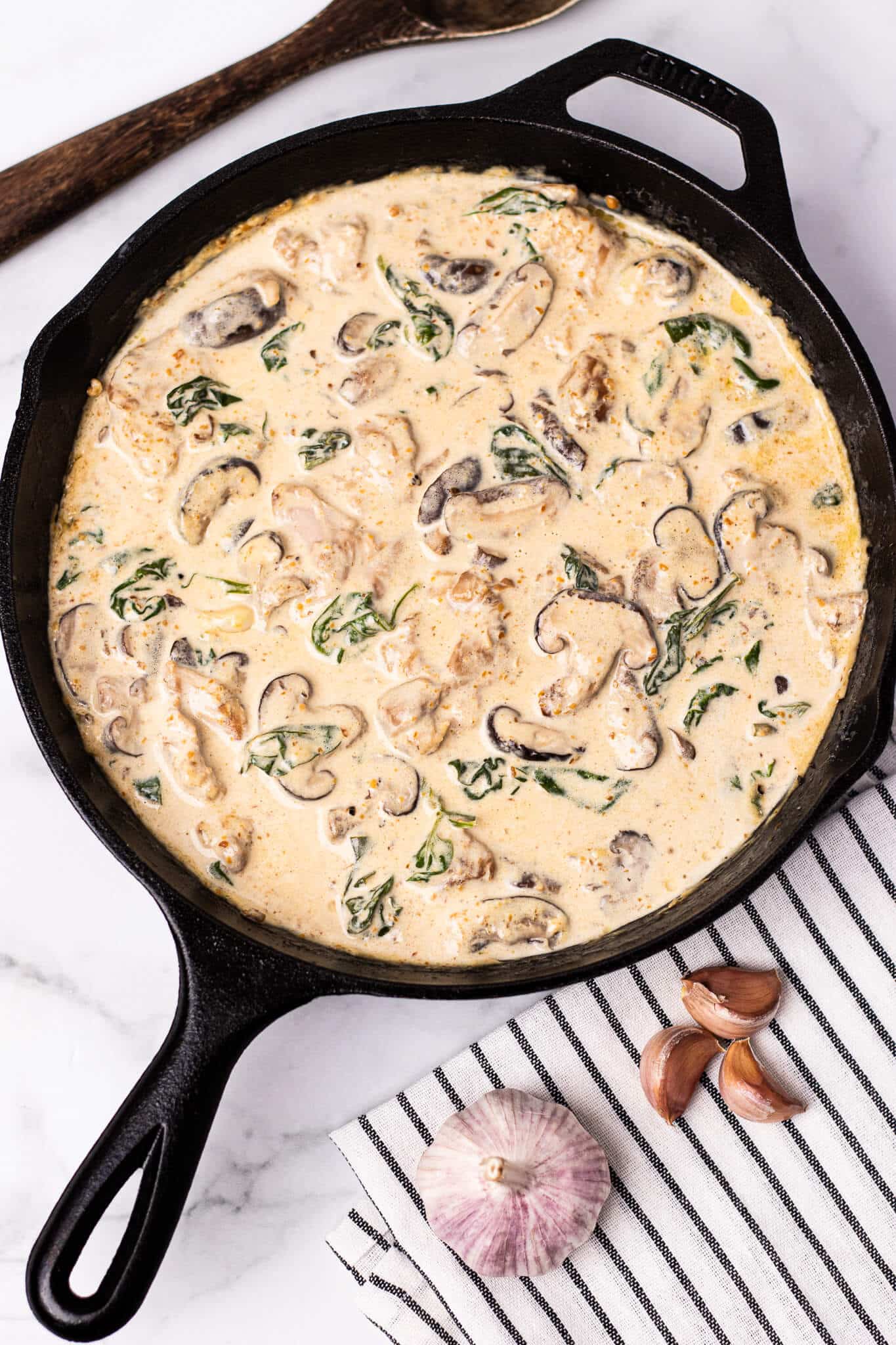 creamy chicken mushroom with spinach in a skillet
