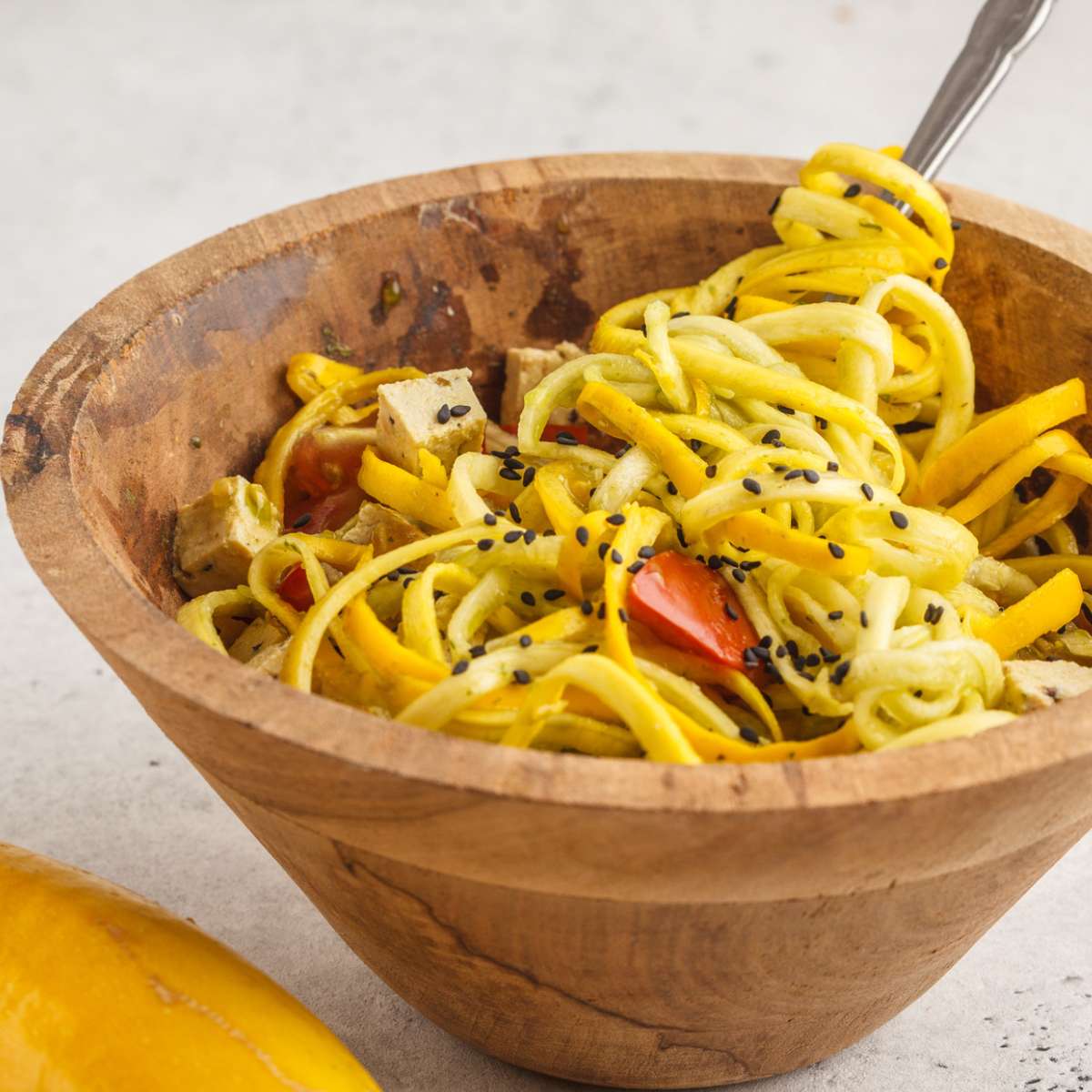 spiralized yellow squash in a wooden bowl