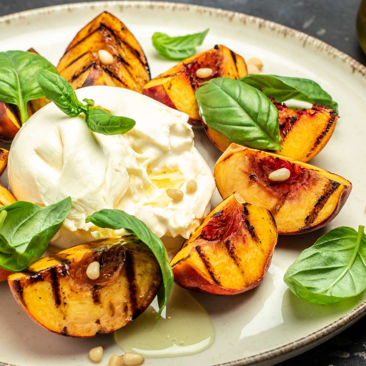 grilled peach recipe with burrata cheese and basil leaves
